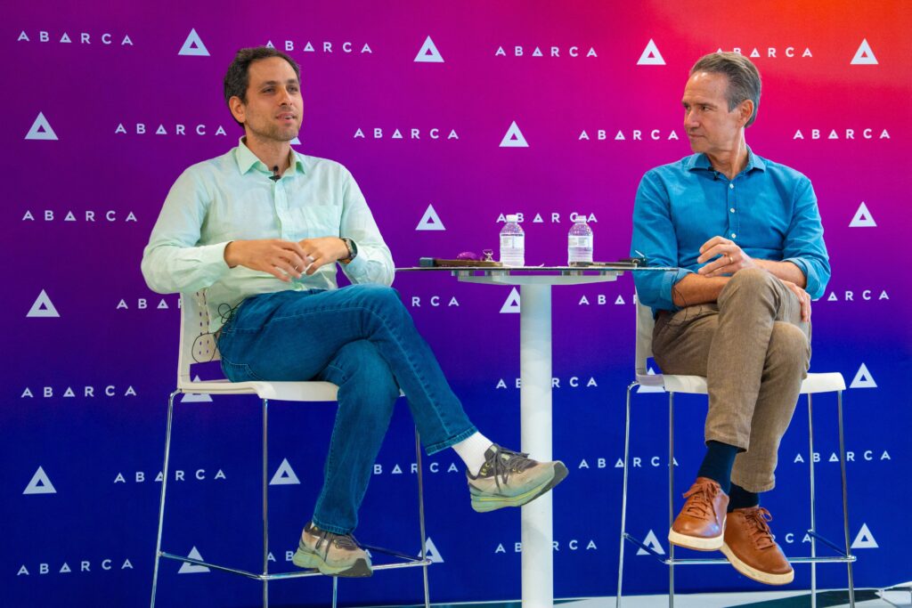 Bertil Chappuis and Jason Borschow seated on stage in front of an Abarca-branded backdrop during Oasis Connections Season 4, Episode 3.